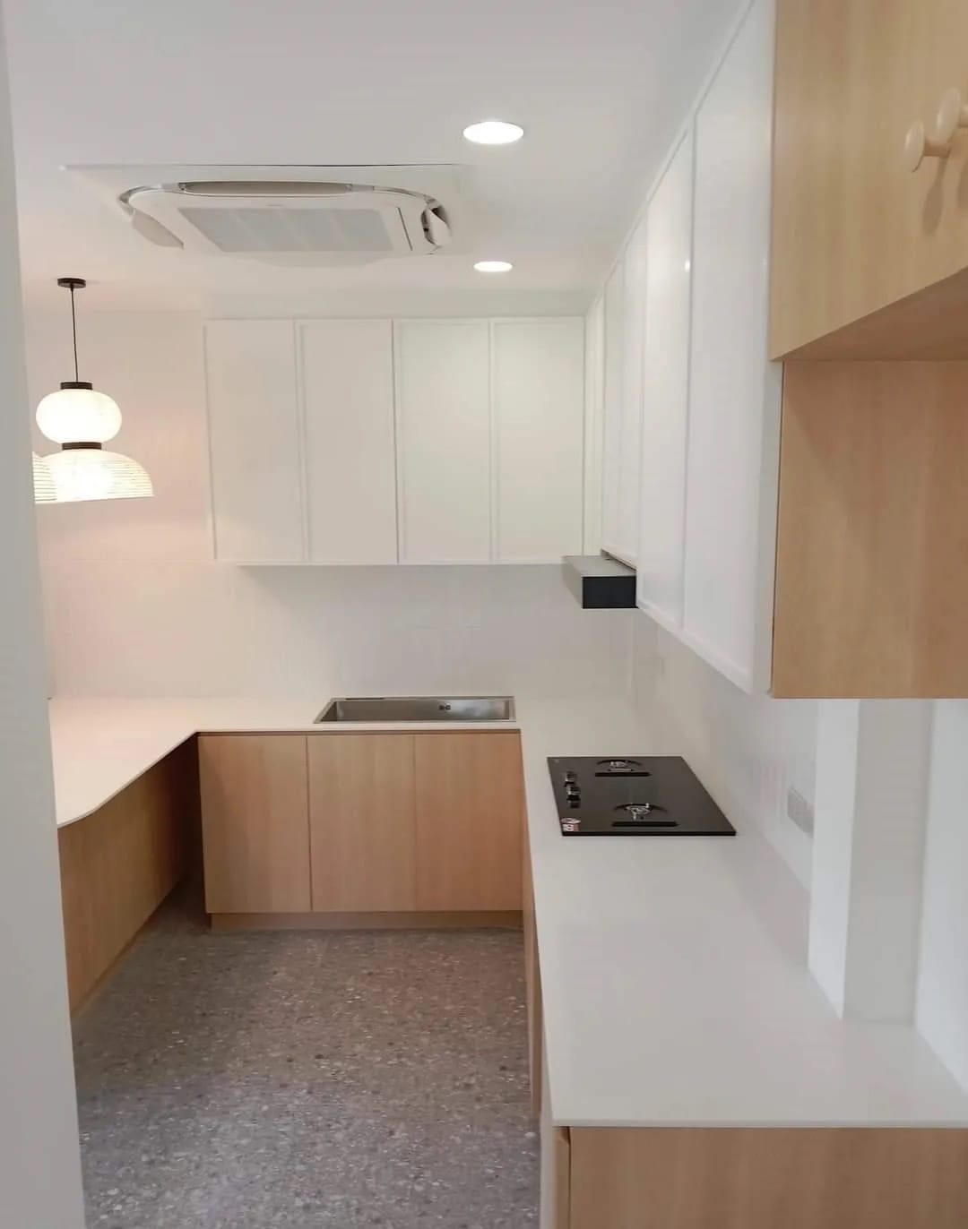 White solid-surface worktop along an L-shaped kitchen